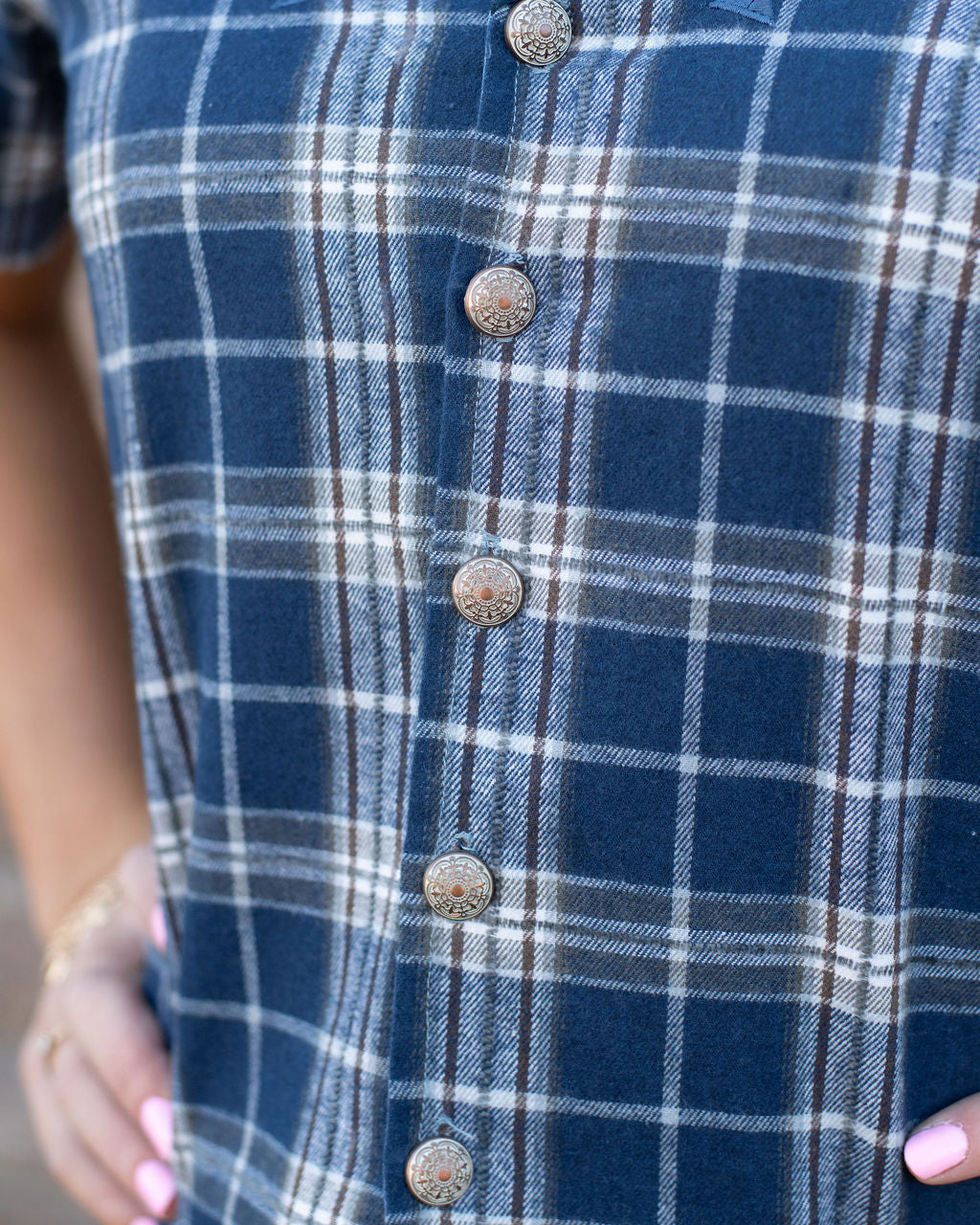 Close-up of a blue plaid shirt with buttons